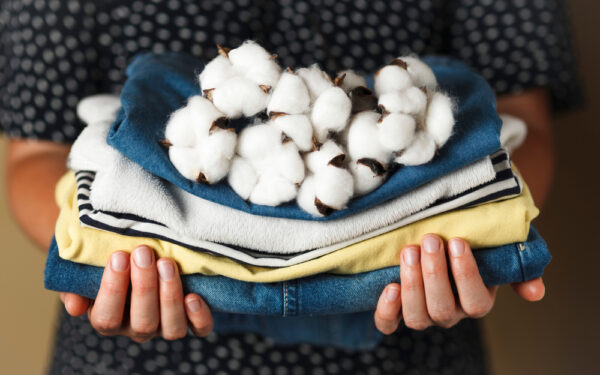 Hands,Hold,A,Stack,Of,Organic,Clothing,And,Cotton,Colors.