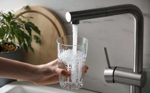 Woman,Filling,Glass,With,Tap,Water,From,Faucet,In,Kitchen,