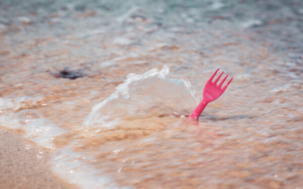 Plastic,Cutlery,Fork,In,Sea,Water,On,Ocean,Beach,,Environmental