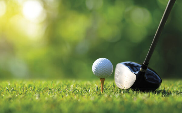 Close-up,Golf,Ball,On,Tee,With,Golf,Drivers,At,Golf
